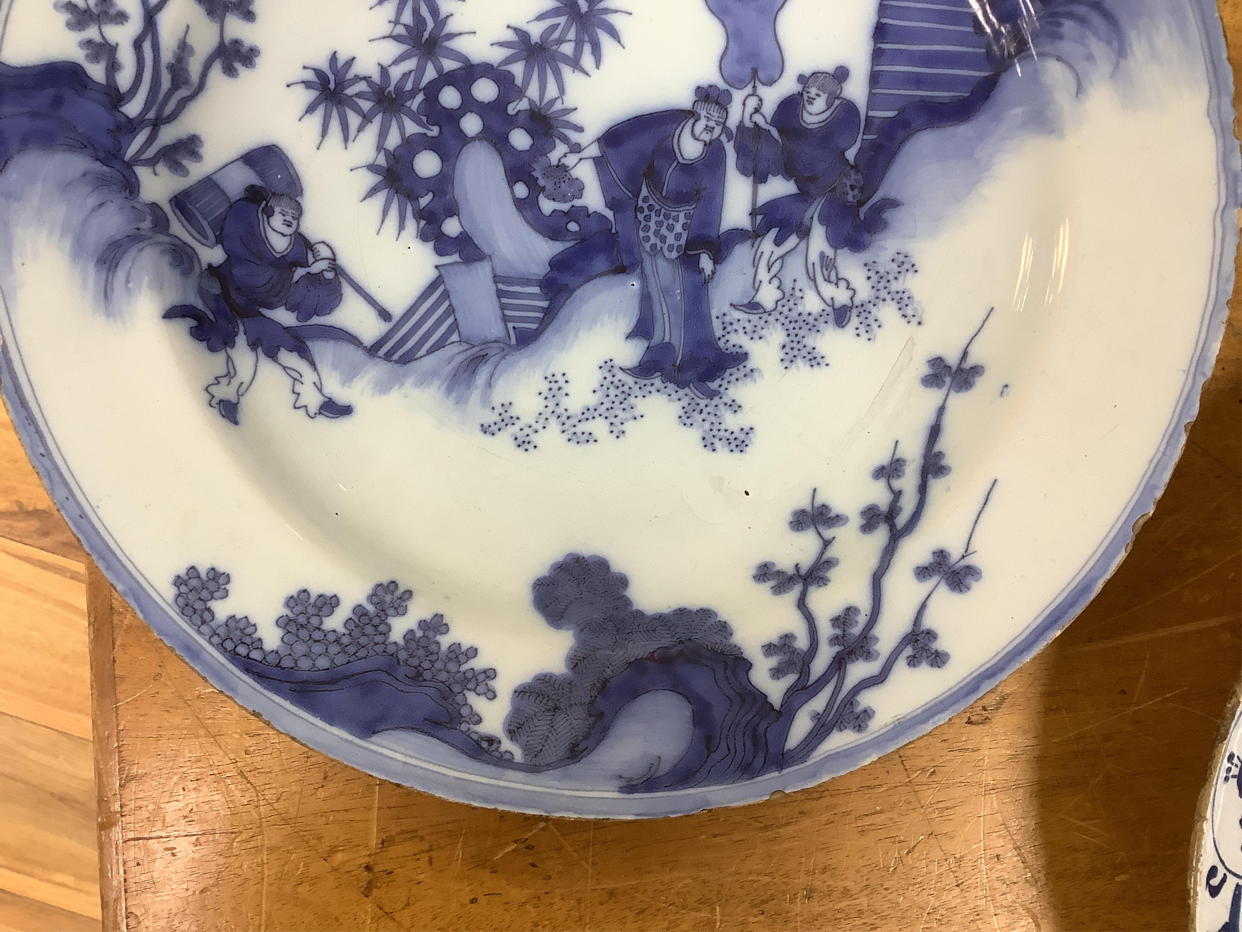 An 18th century English delftware ‘Chinese figures’ dish and two similar Delft dishes, largest 39cm diameter (3), largest 39cm